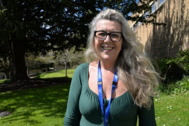 A photograph of Julie Reeve. The image is taken at Yeovil Hospital on the grass in front of the hospital.