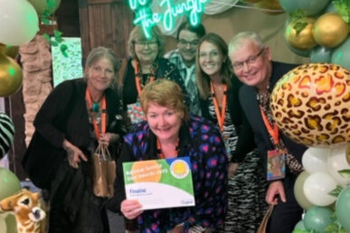 A photo of six people accepting an award certificate.