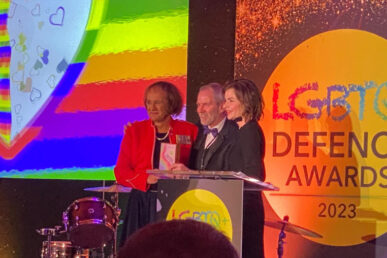 Three people stood on stage at an awards night