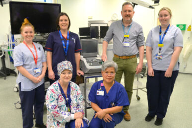A photo of six clinicians stood in an operating theatre
