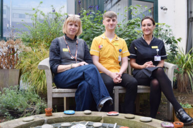 A photo of three hospital staff members sat in the dementia garden at Yeovil District Hospital.