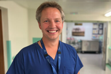 A photo of Consultant Colorectal Surgeon Richard Bamford stood in a hospital corridor.