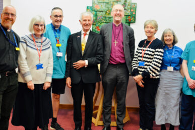 A photo of eight people standing in an area of Musgrove Park Hospital. One of those people is Bishop Michael and the other is Somerset FT chair Colin Drummond.