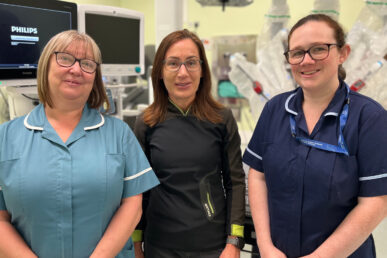 Three colleagues at Yeovil District Hospital who are involved in an anaesthetist study are stood in an operating theatre.