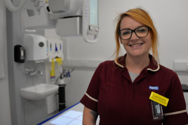 A photo of apprentice radiographer Lucie Armson stood in a treatment room.