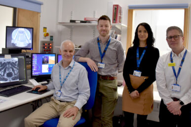 A photo of four healthcare colleagues stood inside a radiology reporting room.